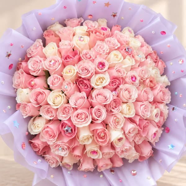 Large bouquet of pink and white roses wrapped in lavender paper