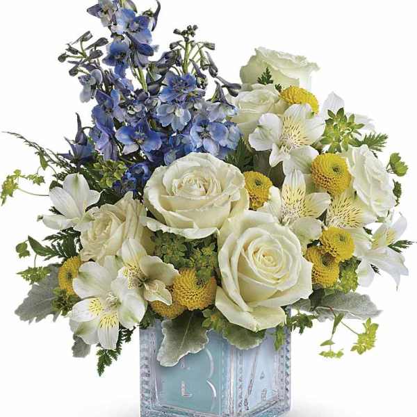 Blue and white floral arrangement in a clear square vase