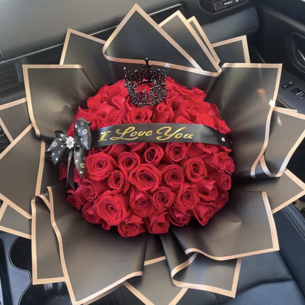 Bouquet of red roses wrapped in black paper with gold trim