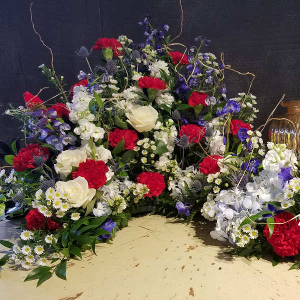 Large red, white, and blue floral arrangement with roses and carnations