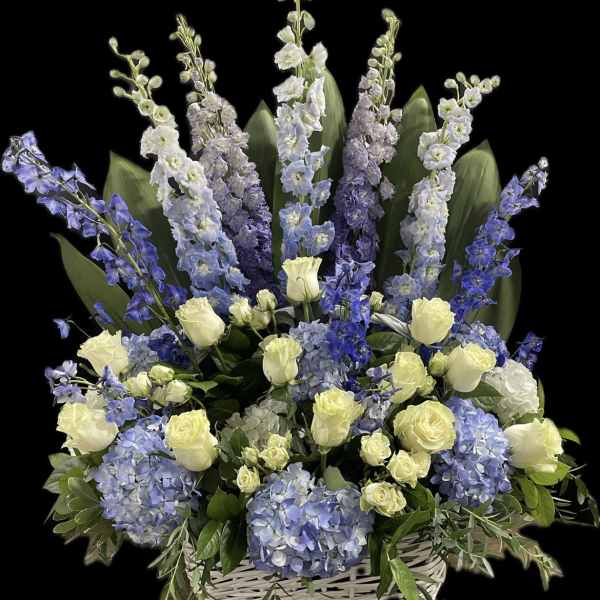 Blue and white floral arrangement in a white basket