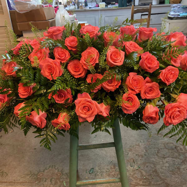 Large bouquet of coral roses with fern greenery
