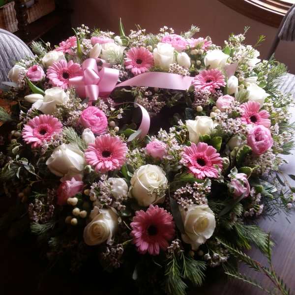 Pink and white floral wreath with a pink ribbon bow