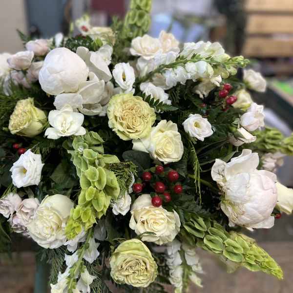 Large white and pale green floral arrangement with roses and lilies