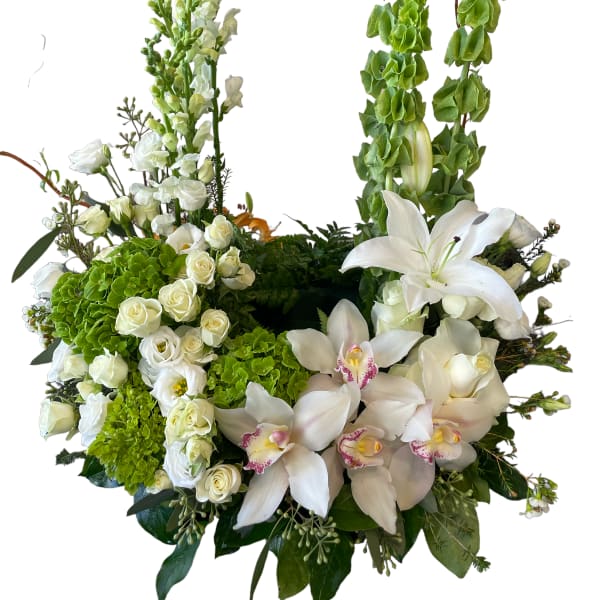 White floral arrangement with lilies, roses, and orchids
