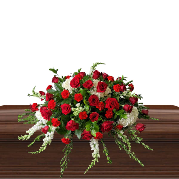Red roses and white flowers arranged on a casket
