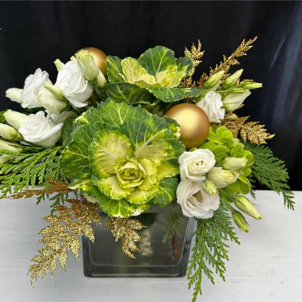 White roses and green ornamental cabbage in a glass vase with gold accents
