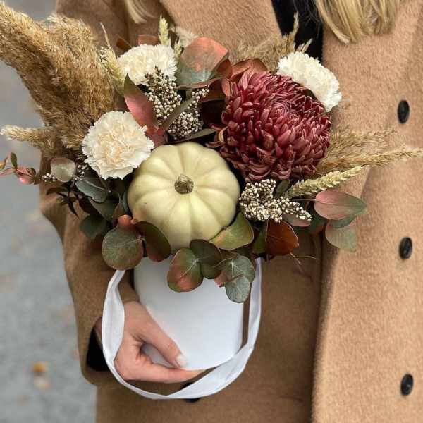 Autumn bouquet with chrysanthemums and a small pumpkin in a white bucket