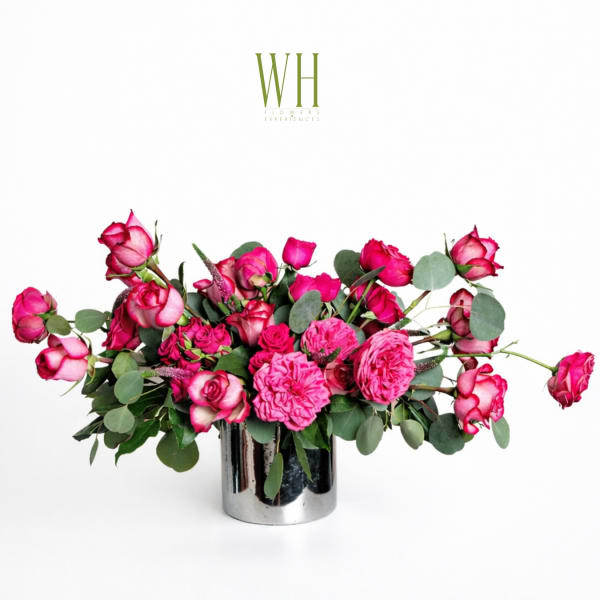Pink roses and ranunculus in a silver vase