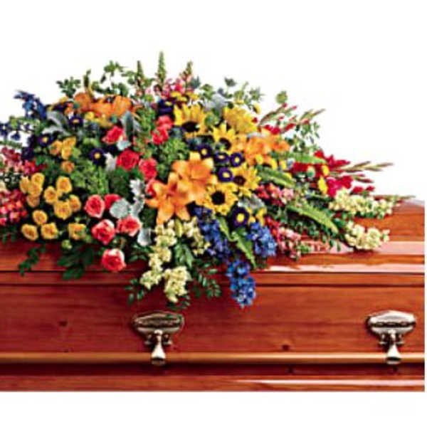 Colorful floral casket spray on a wooden coffin