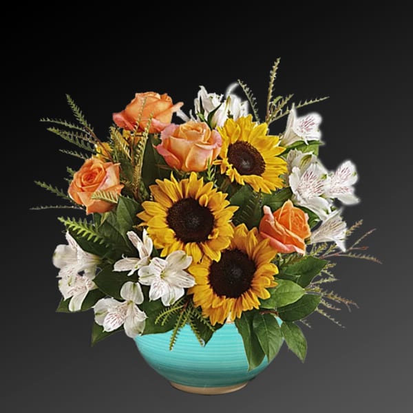 Sunflowers, peach roses, and white alstroemeria in a turquoise bowl vase