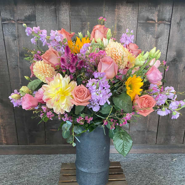 Mixed bouquet in a blue vase with pink roses and purple flowers