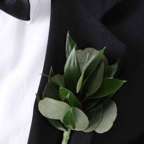 Green boutonniere pinned to a black suit jacket