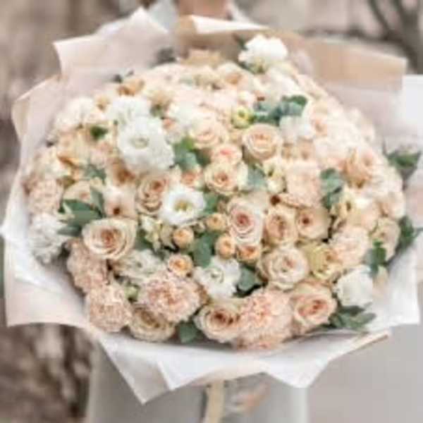 Large bouquet of pale peach and white roses wrapped in white paper