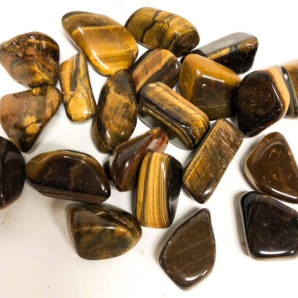 Polished tiger's eye stones arranged on a white background