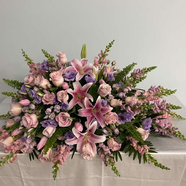Low floral centerpiece with pink lilies, roses, and purple blooms