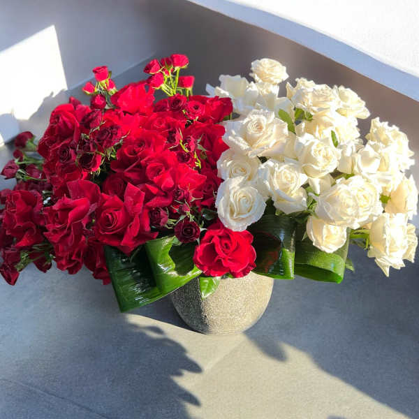 Red and white rose arrangement in a round vase