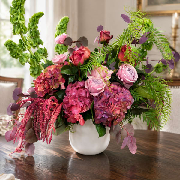 Pink and purple floral arrangement in a white vase