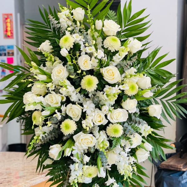 Large white floral standing spray with roses and chrysanthemums