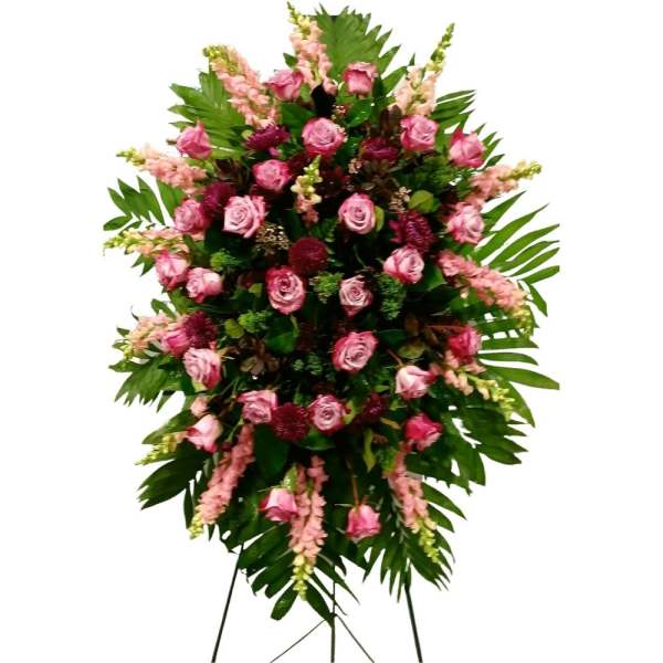 Standing floral spray of pink roses and pink snapdragons with dark greenery
