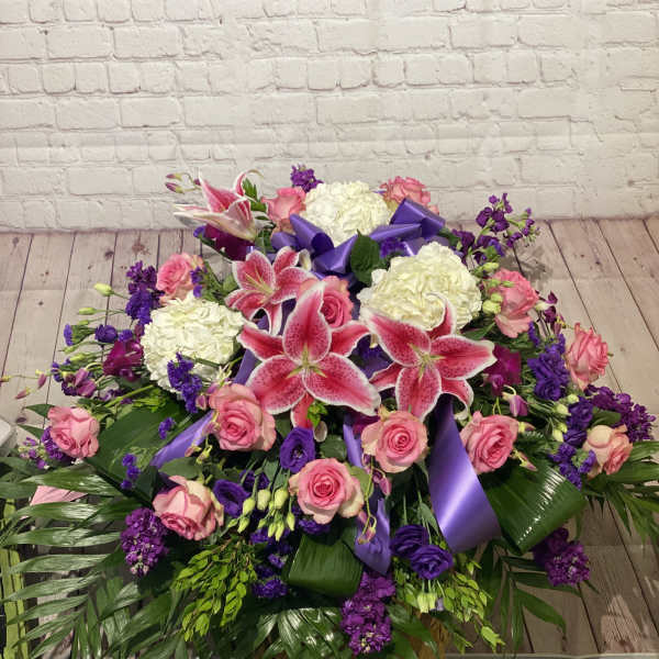 Large bouquet of pink roses, white hydrangeas, and pink lilies with purple ribbon