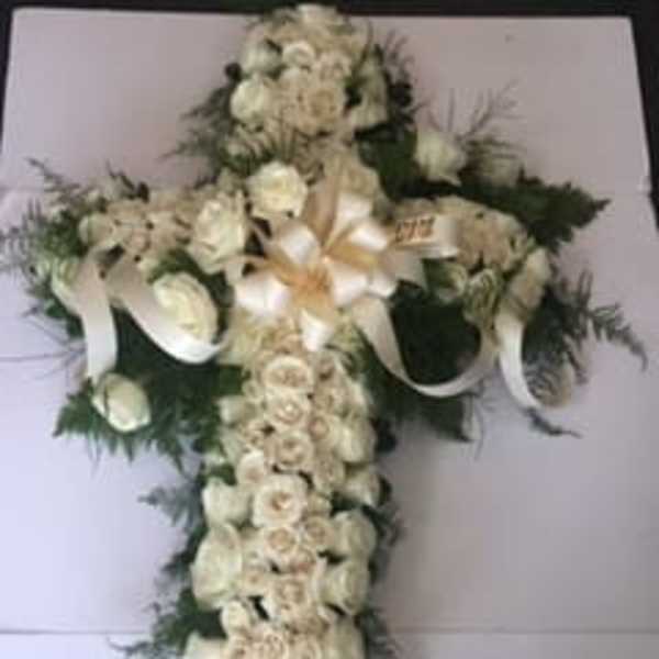White floral cross arrangement with ribbon accents