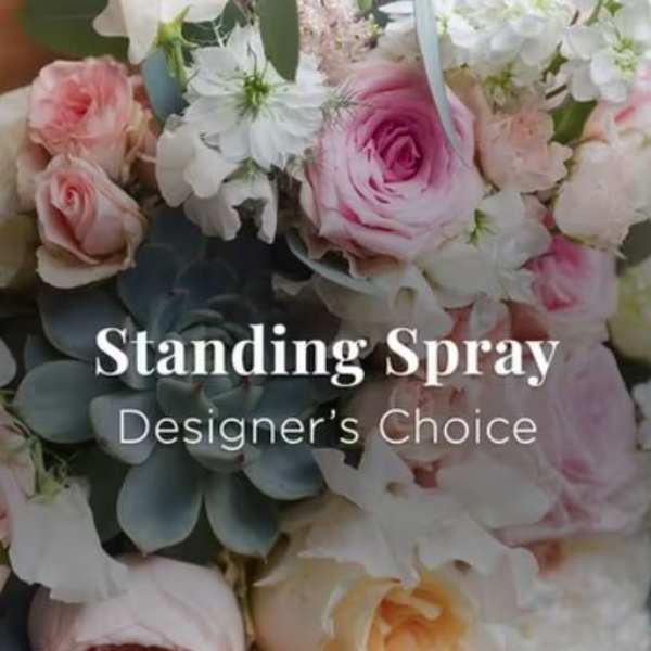 Standing spray of pink and white flowers with blue-green foliage