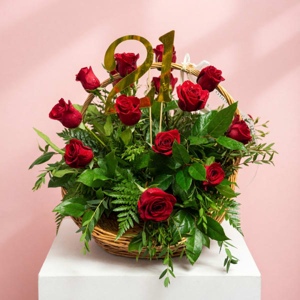 Basket of red roses with a gold "21" topper
