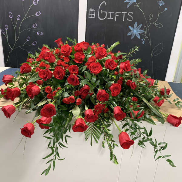 Large arrangement of red roses with trailing greenery