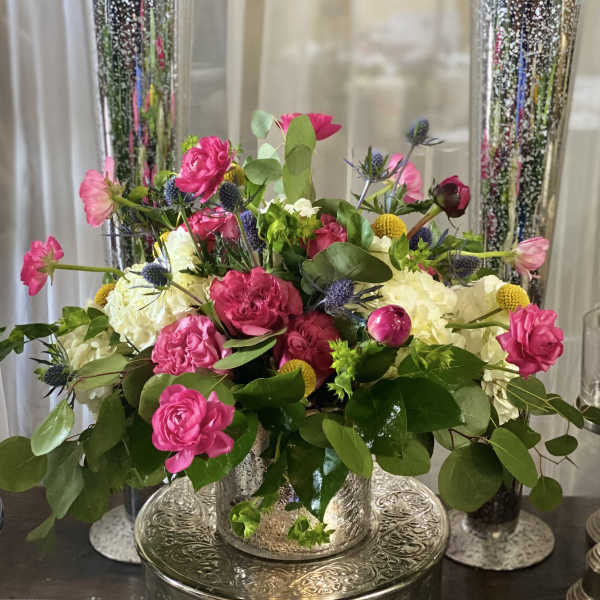 Pink and white floral arrangement in a silver vase