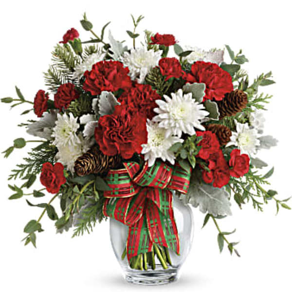Red and white floral arrangement in a glass vase with a plaid ribbon