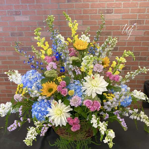 Large mixed flower basket with blue, yellow, pink, and white blooms