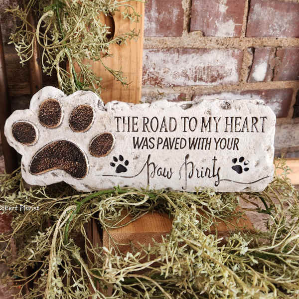 Decorative stone plaque with a paw print and memorial text