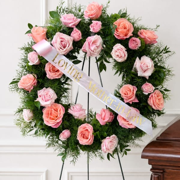 Pink and peach rose wreath on an easel with a ribbon reading Loving Mother-in-law