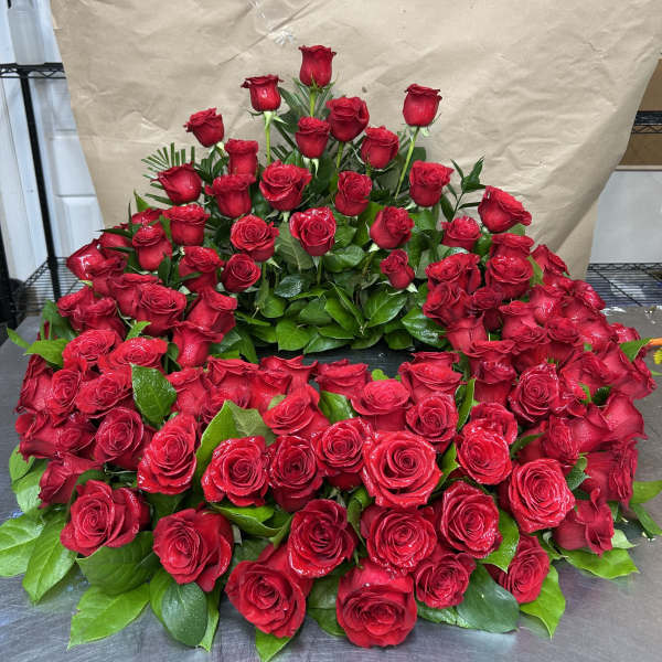 Large arrangement of red roses with green leaves