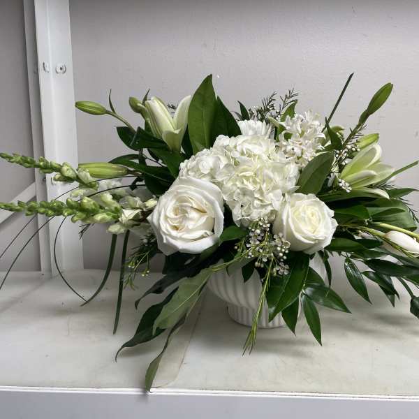 White roses and lilies arranged in a white vase