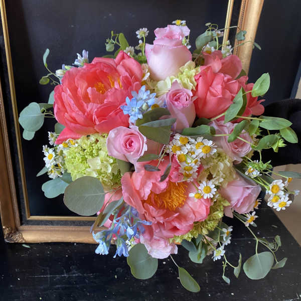 Bouquet of pink roses and peonies with small daisies