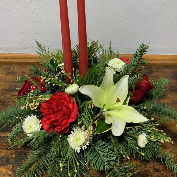 Holiday centerpiece with red candles, lilies, and red and white flowers