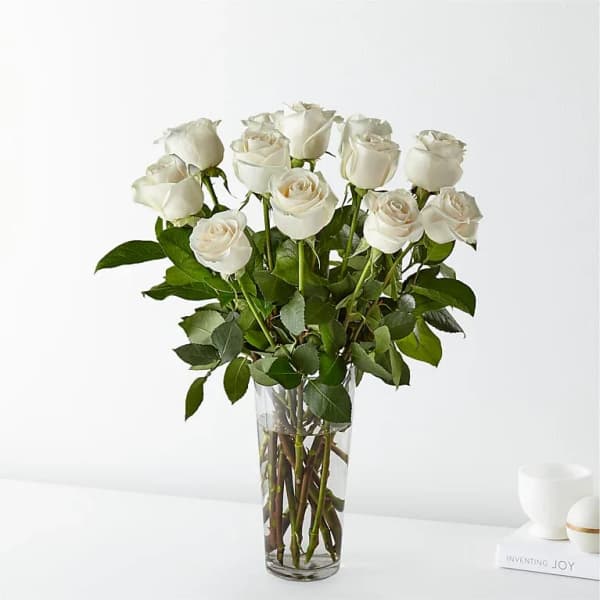 White roses arranged in a clear glass vase