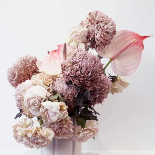 Pink and cream floral arrangement in a pale vase