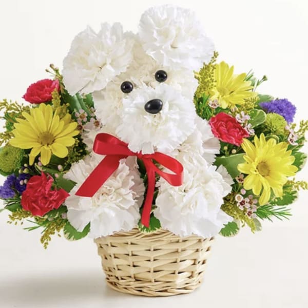 White teddy bear made of flowers in a wicker basket with a red bow