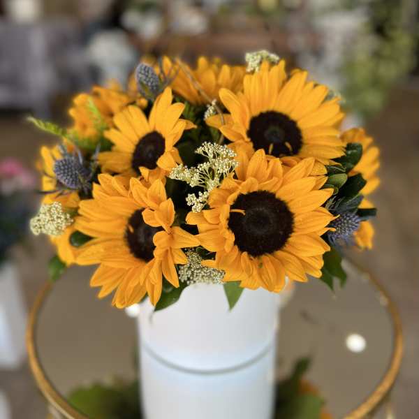 Bouquet of yellow sunflowers in a white vase