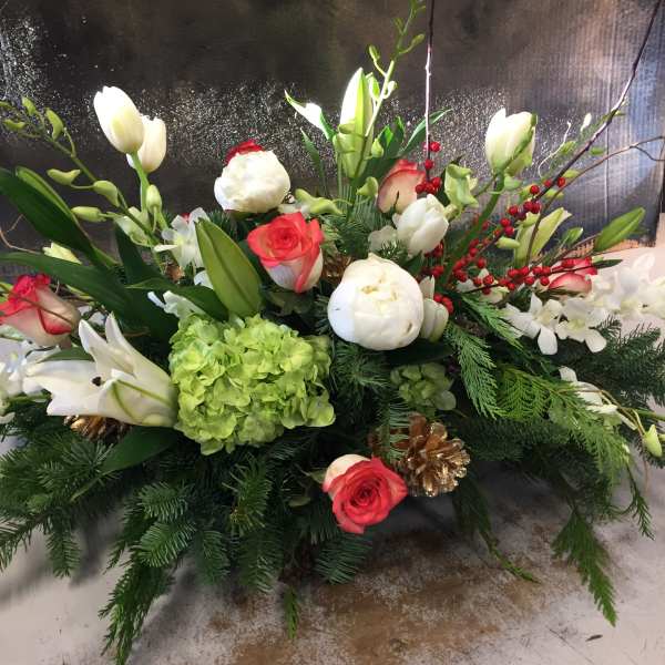 Holiday floral arrangement with white lilies, red roses, and green hydrangea
