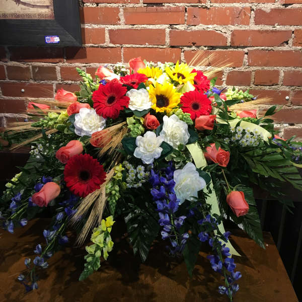 Large mixed floral arrangement with red, yellow, white, and coral blooms