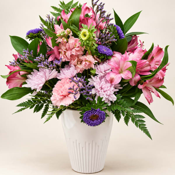 Pink and purple mixed bouquet in a white vase