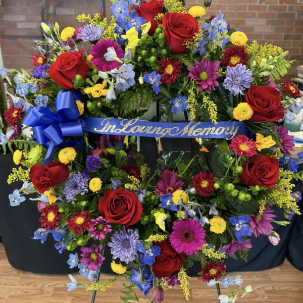 Large memorial wreath with red roses and mixed colorful flowers