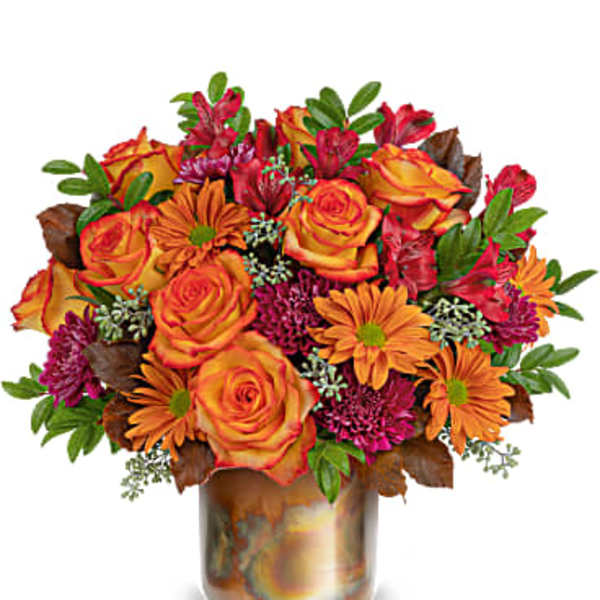 Orange roses and daisies in a metallic vase