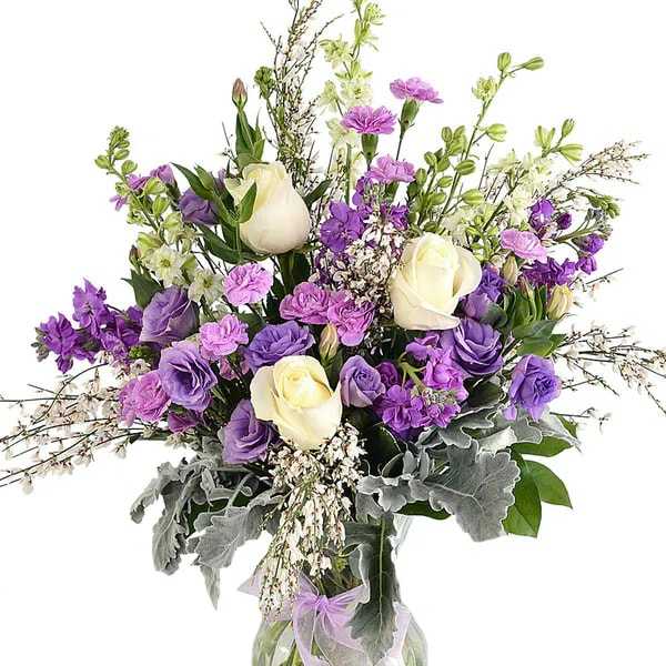 Purple and white bouquet in a clear glass vase