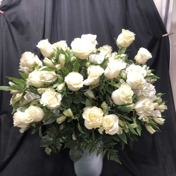 White rose arrangement in a silver pedestal vase