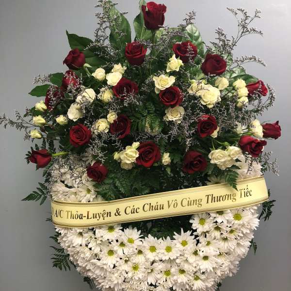 Standing funeral wreath of red and white roses with white daisies